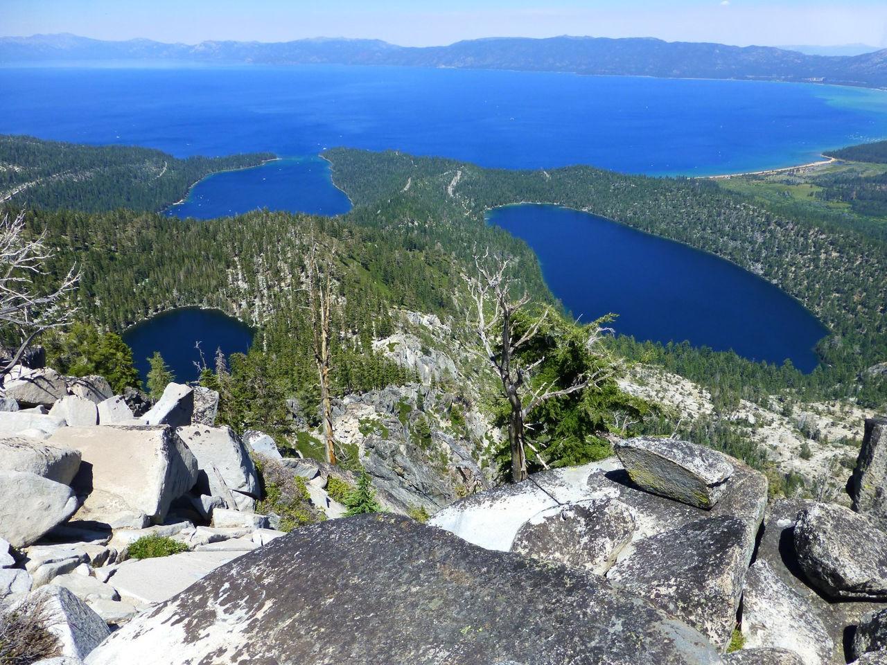 High-angle view of multiple blue lakes surrounded by forests and mountains.