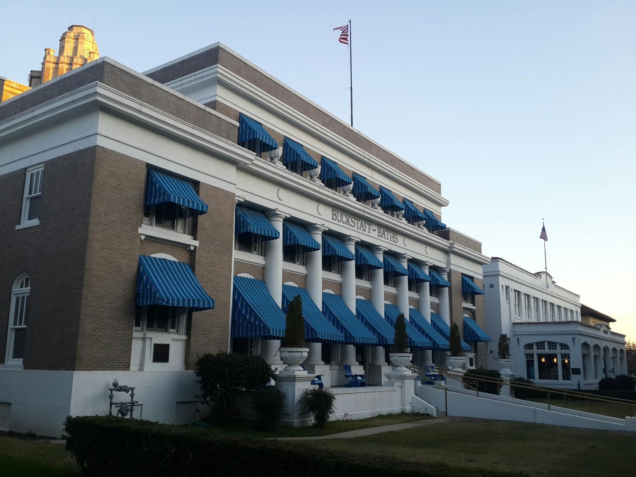 Historic building with blue striped awnings and columns under a clear sky.