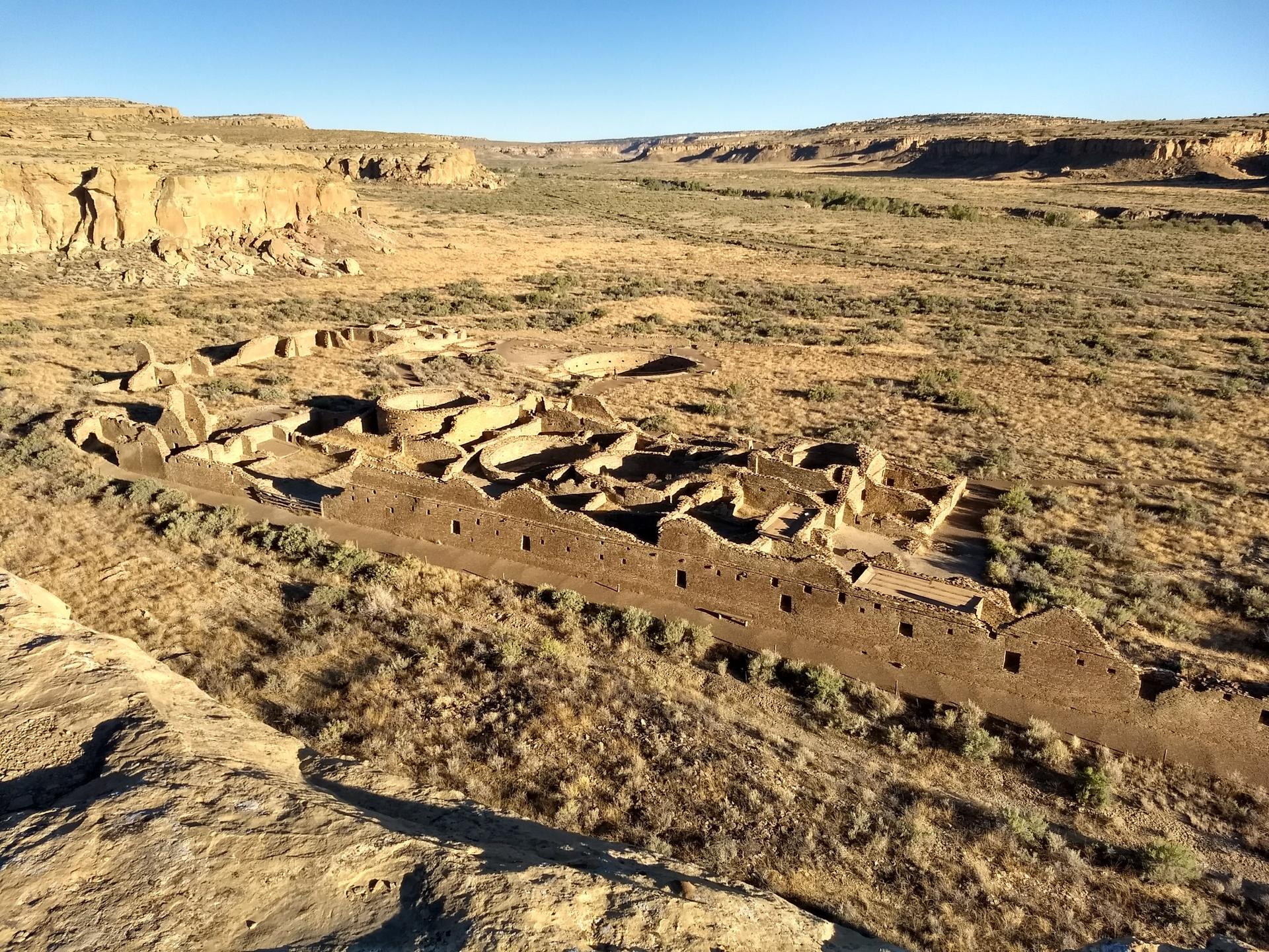 High angle view of extensive stone ruins in a dry, expansive desert valley.