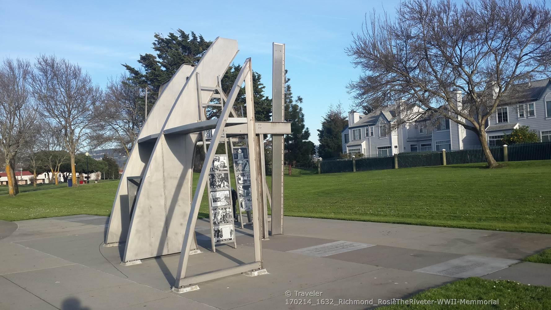 Abstract metal sculpture in a sunny park with residential buildings.