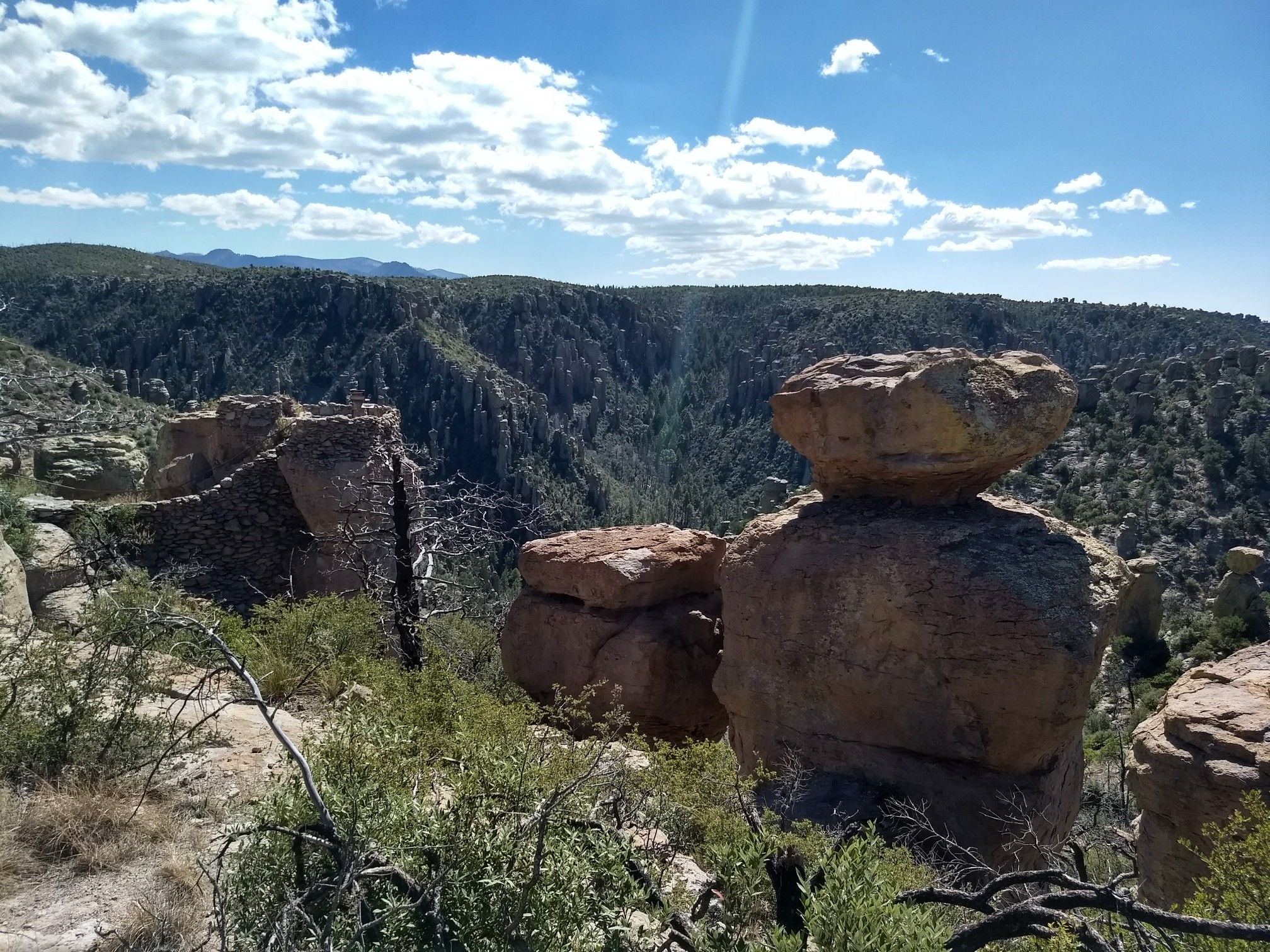 Large, mushroom-shaped rock formations overlooking a forested valley on a sunny day. - Heart of Rocks from Echo Canyon Trailhead