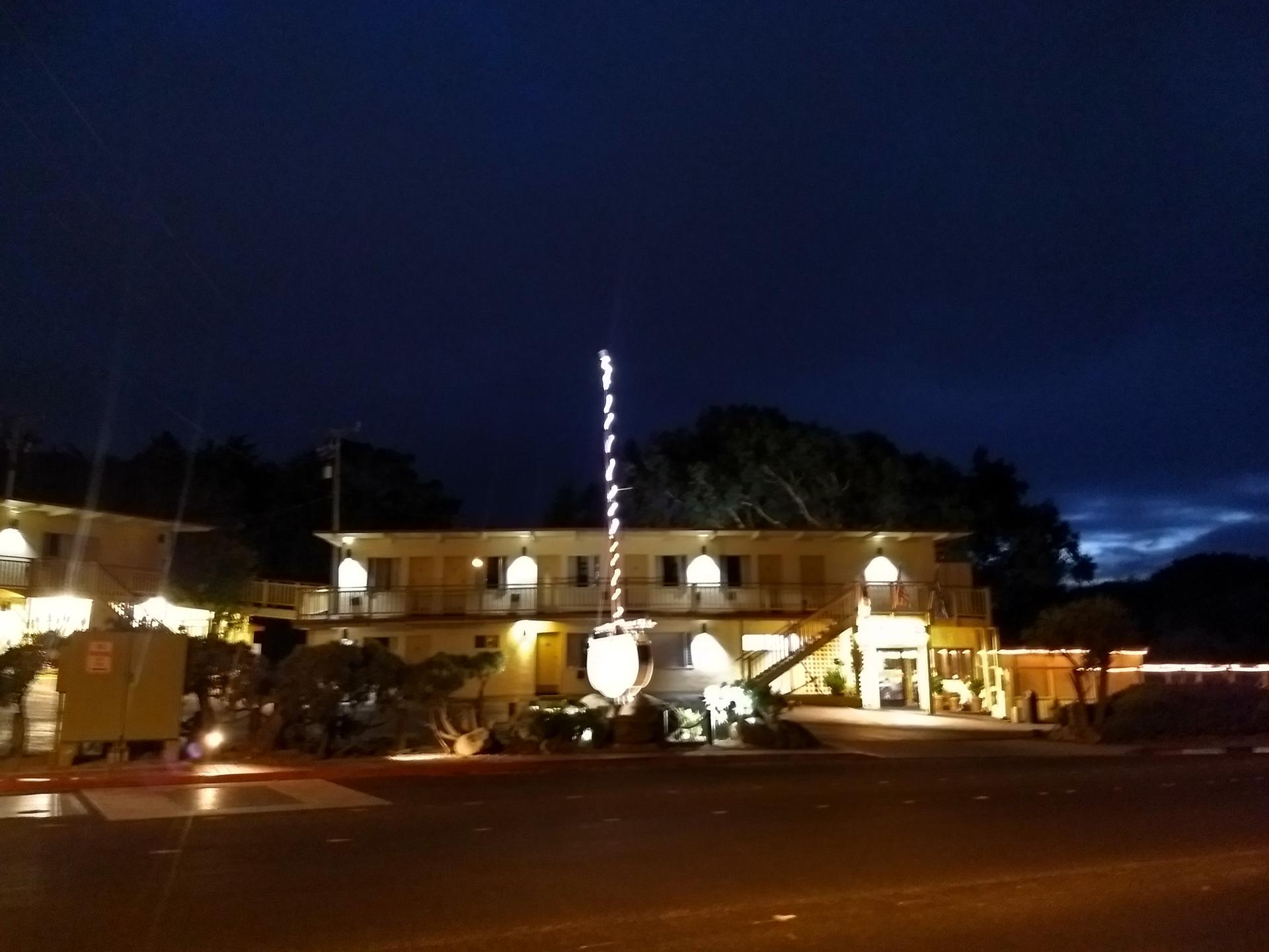 Building illuminated with string lights at night under a dark sky.