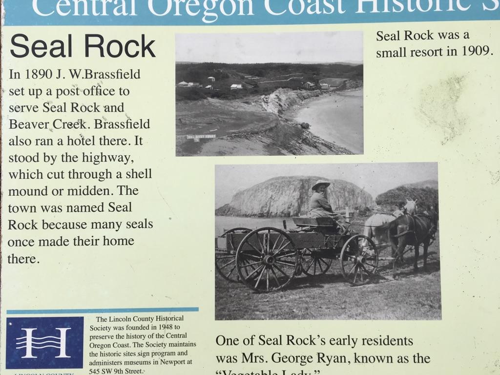 A light green historical sign featuring text and two old black and white photographs.