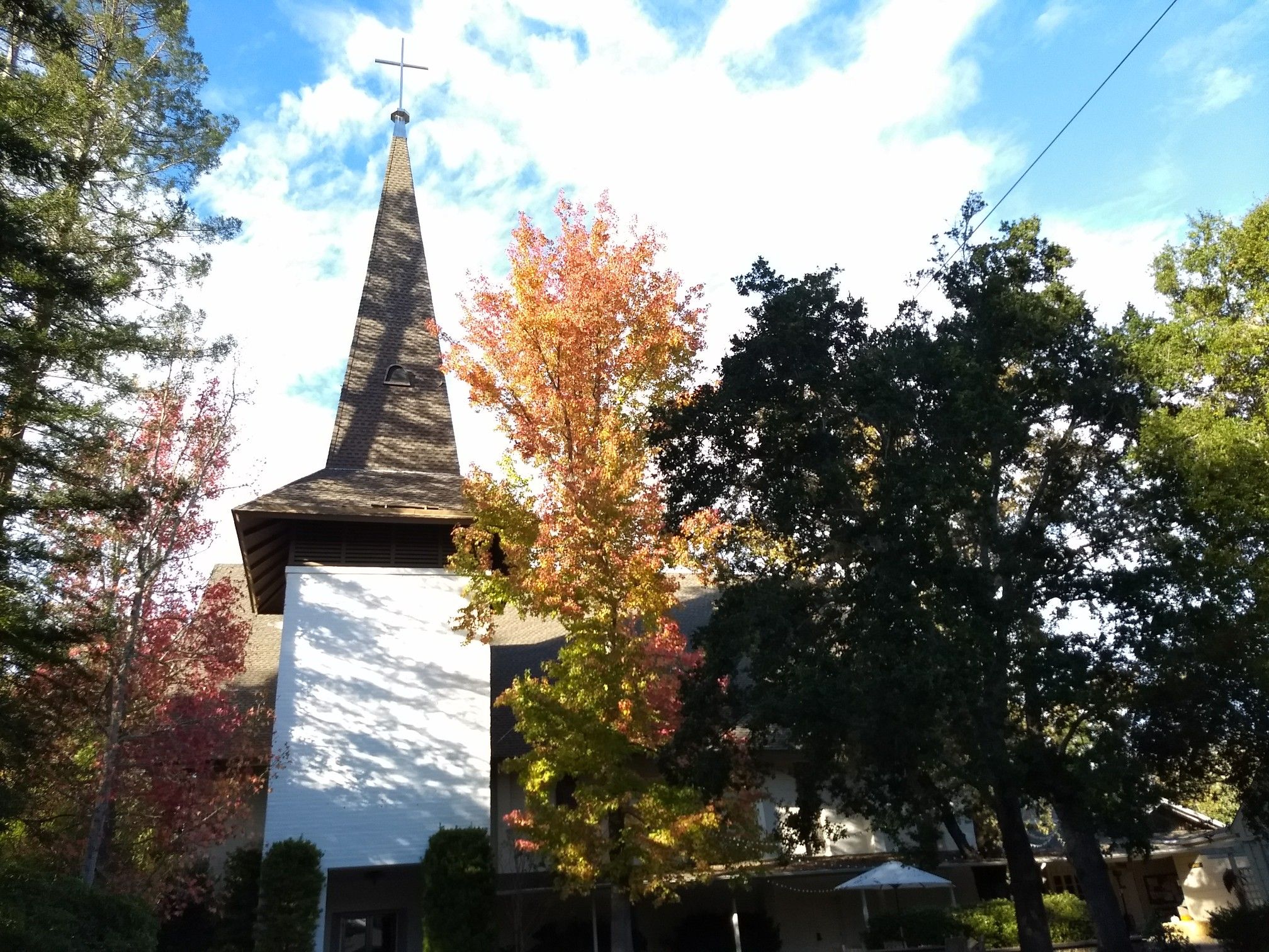 Church steeple with a cross, surrounded by colorful autumn trees. - Woodside – Woodside Village Church loop from Woodside