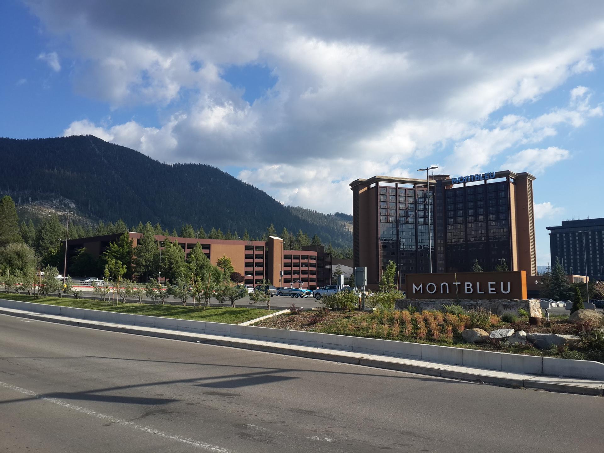 Large hotel buildings with mountains in the background under a partly cloudy sky.