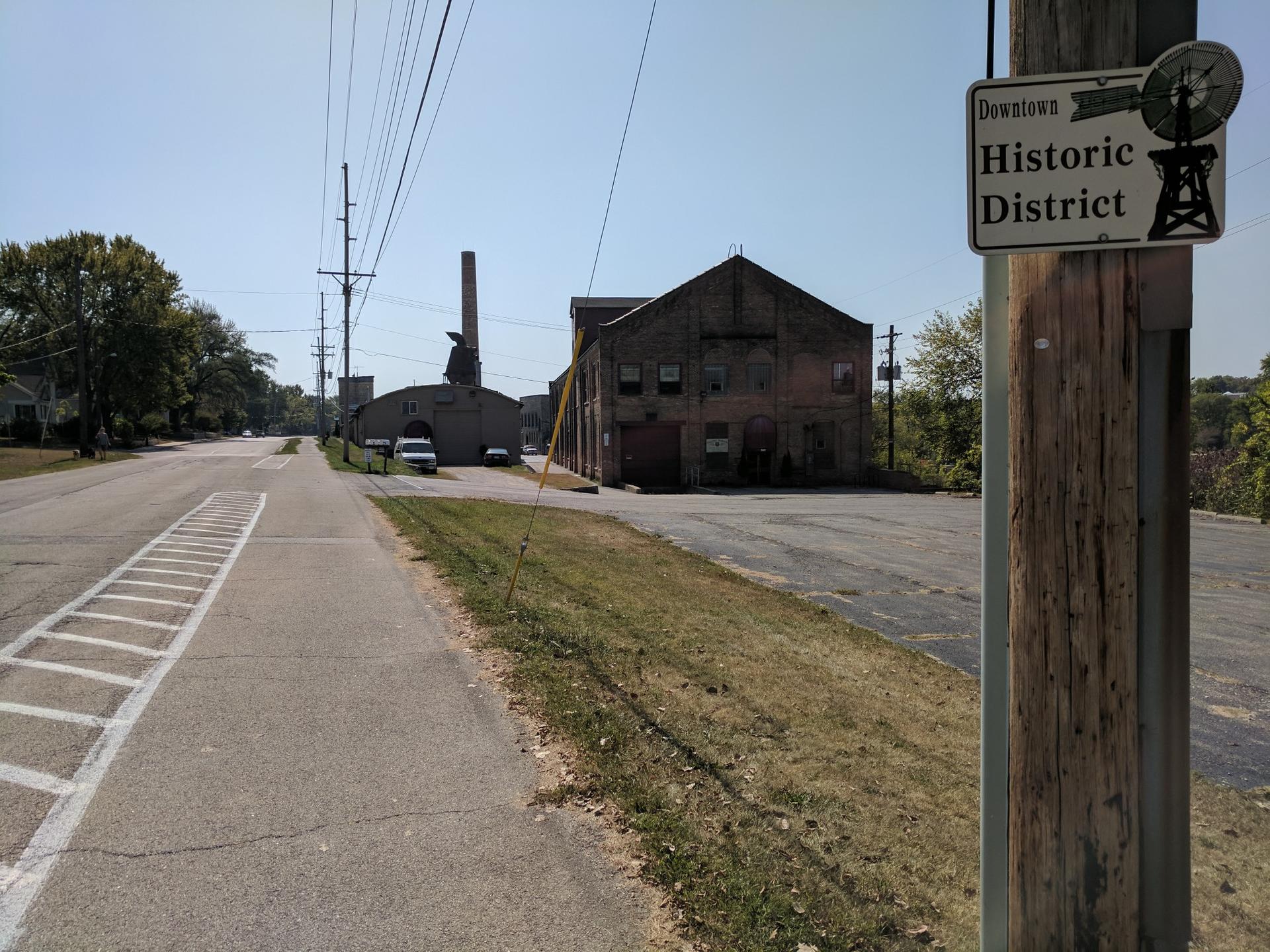 Street scene with old brick buildings, power lines, and a "Historic District" sign.