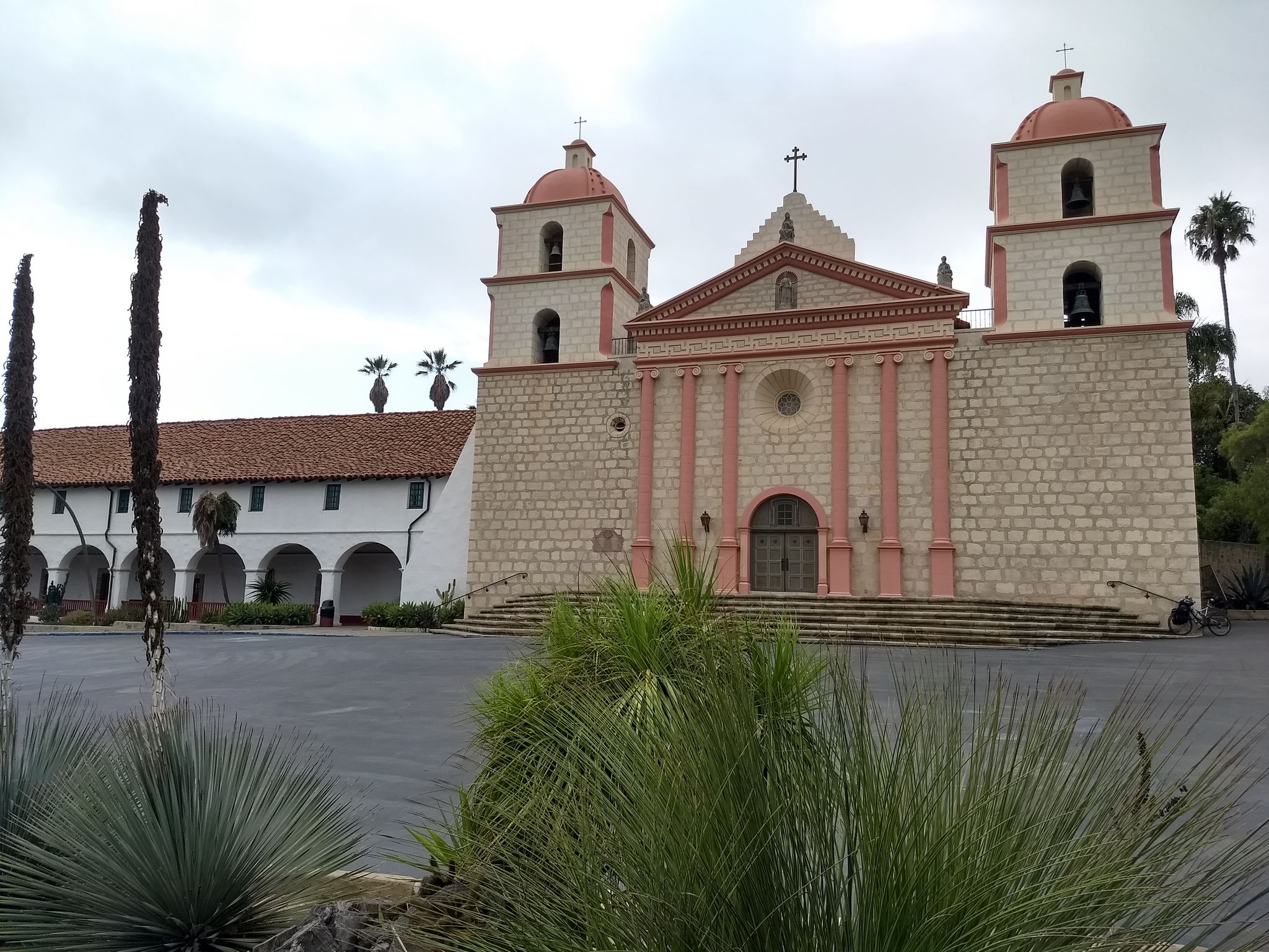 Historic mission building with twin bell towers under an overcast sky. - La Cumbre Peak loop