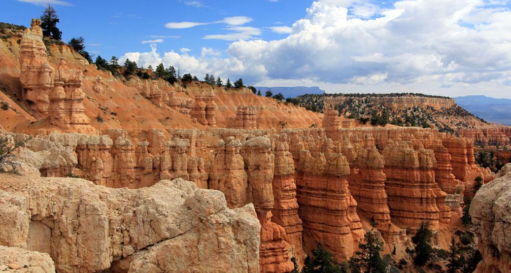 Close-up of towering orange and white rock formations under a cloudy sky.