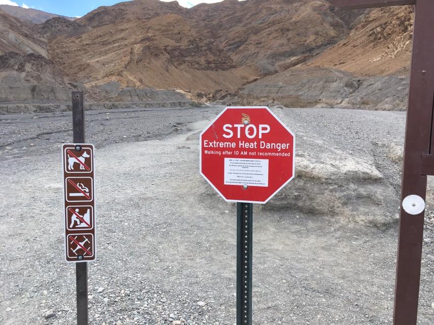 Red "STOP Extreme Heat Danger" sign on a gravel path.