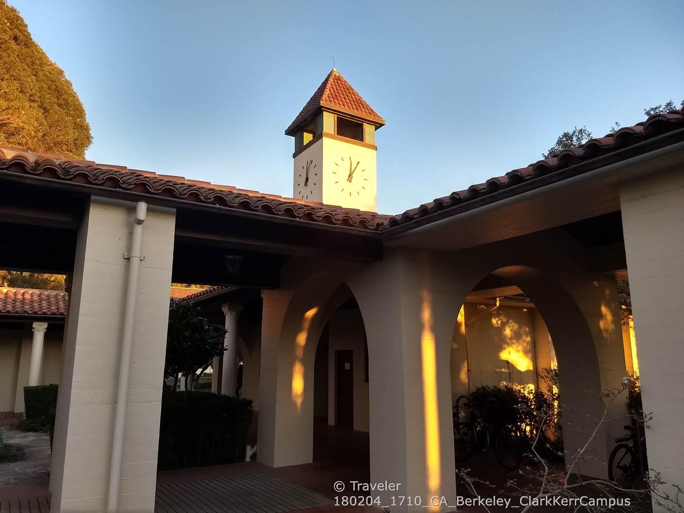 Clock tower and arched walkway bathed in warm, golden sunlight.