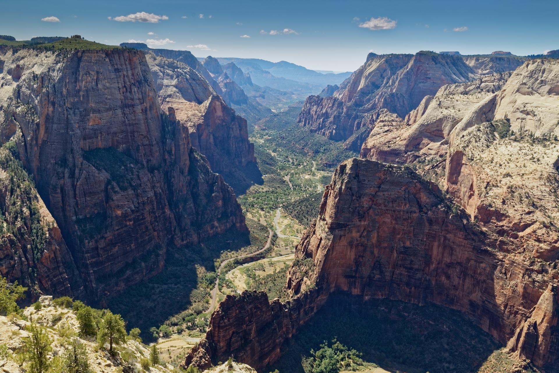 Expansive view of a deep canyon with a winding green valley below.