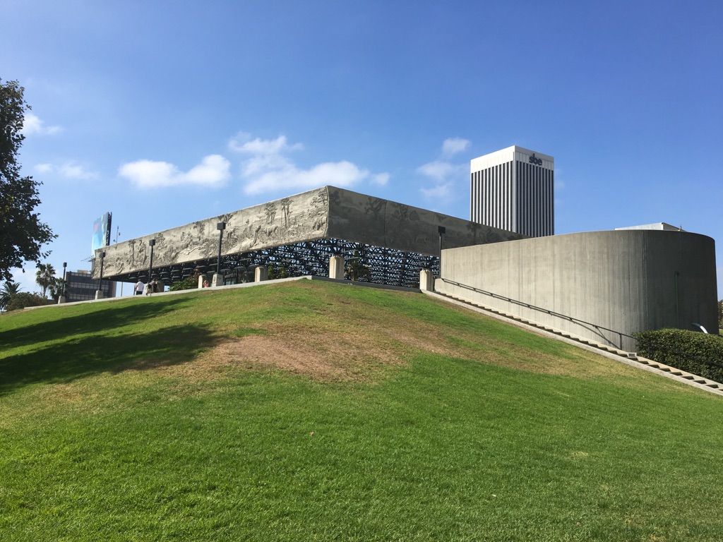 Modern concrete building on a green grassy hill under a clear blue sky. - Hancock Park and La Brea Tar Pits Loop