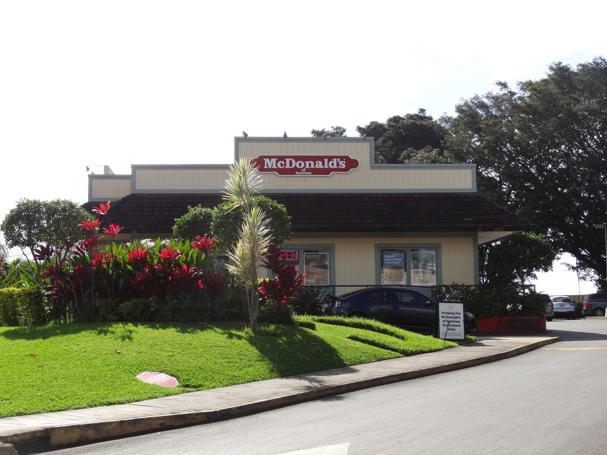 McDonald's restaurant building with lush landscaping on a bright day.