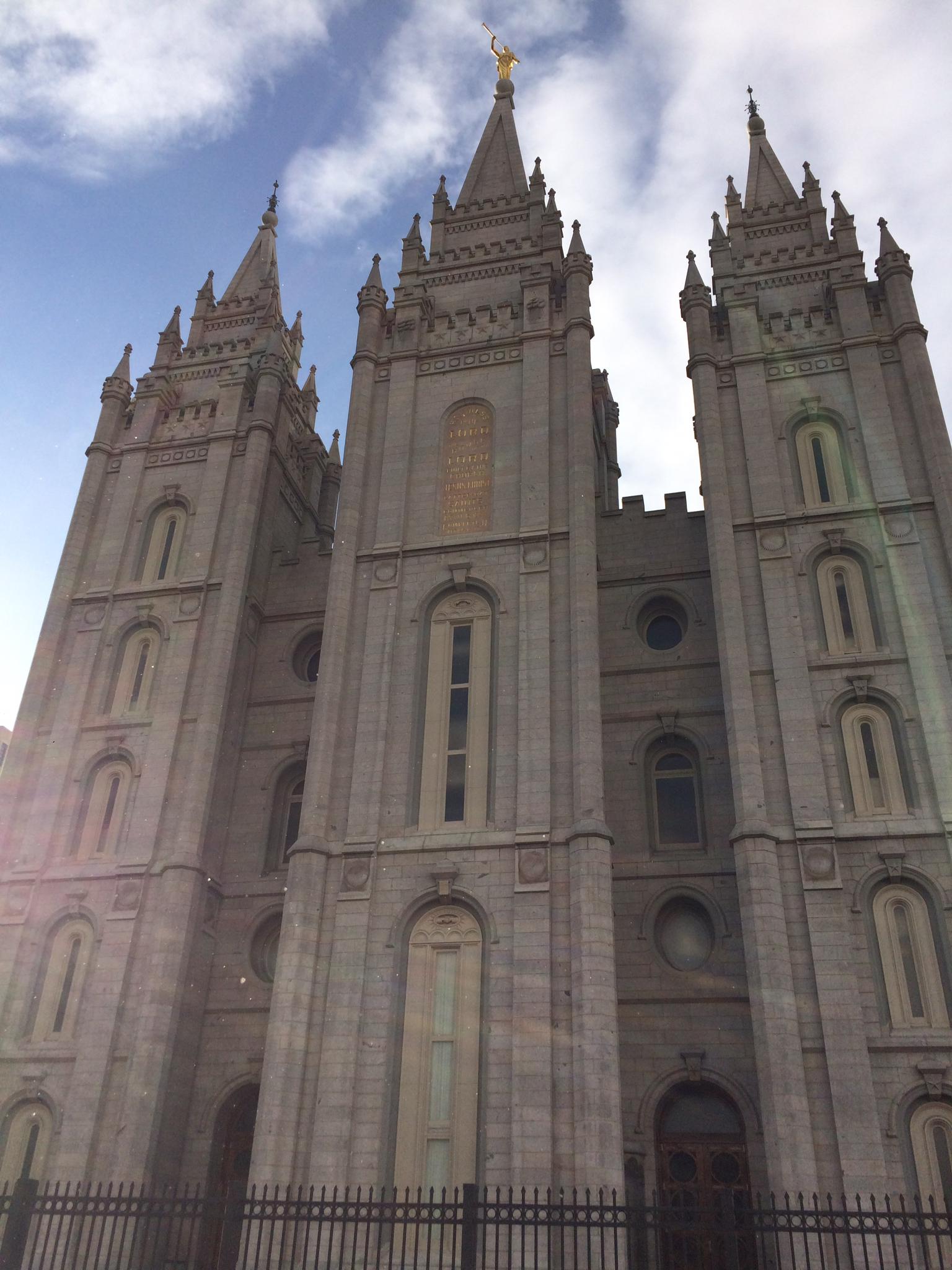 Ornate stone building with multiple spires reaching towards a bright sky.
