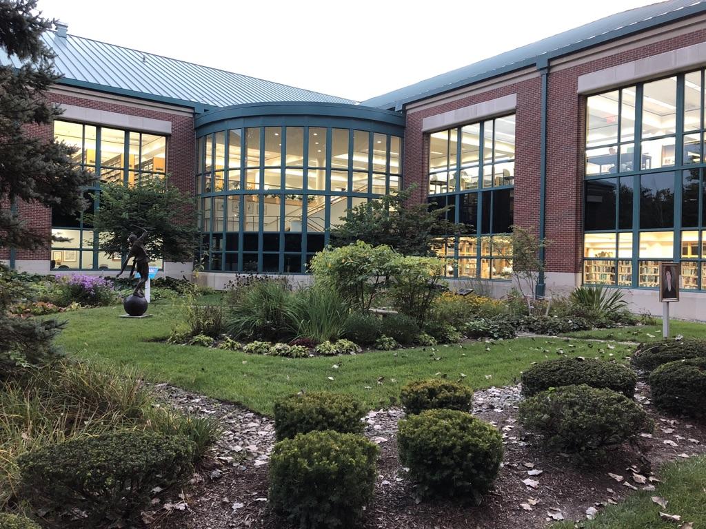 A modern brick building with large windows and a landscaped garden.