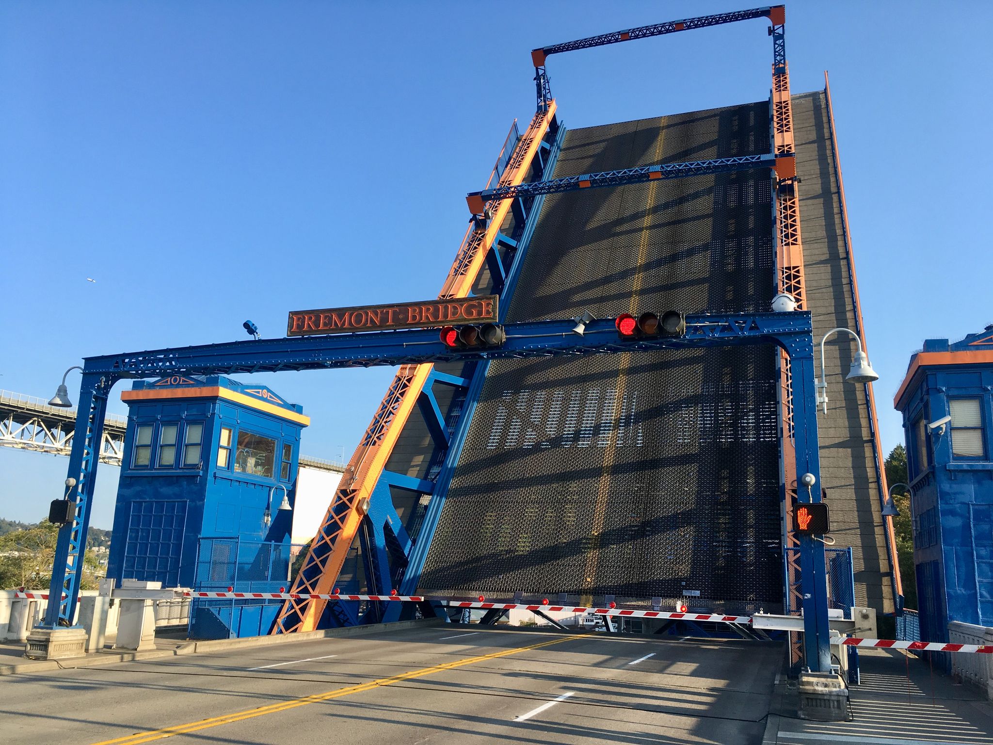 A large blue drawbridge is open, angled upwards, under a clear sky. - Cheshiahud Lake Union Loop