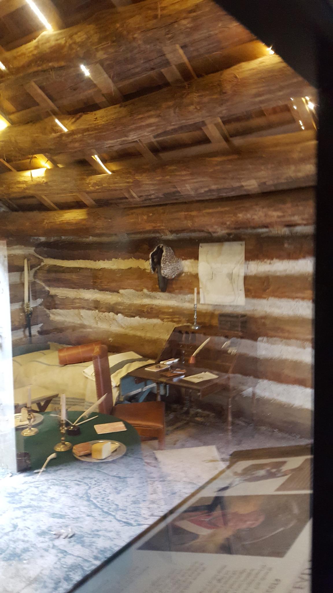Rustic log cabin interior with warm lighting and simple furnishings.