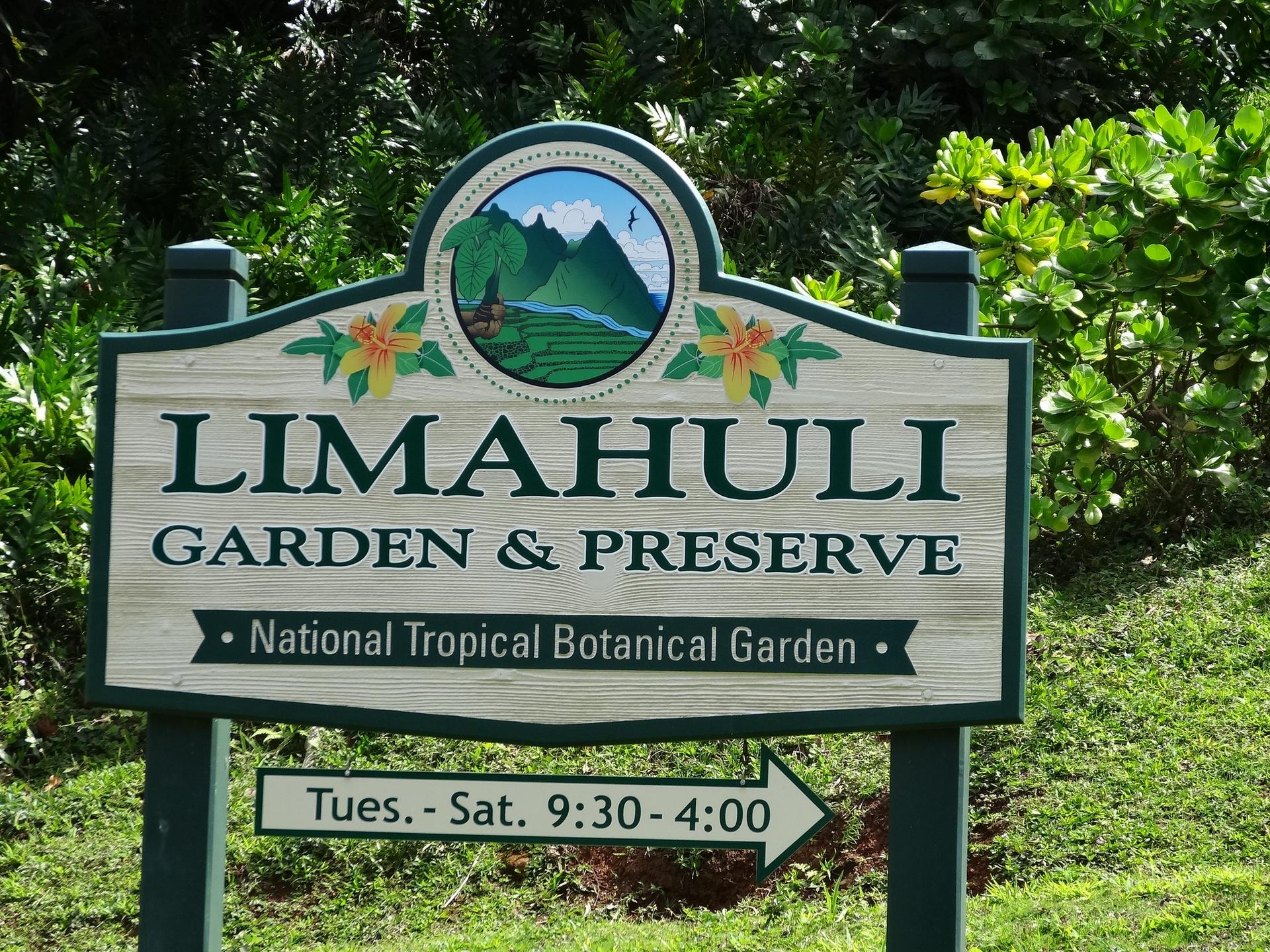 Wooden sign for a garden and preserve surrounded by green foliage.