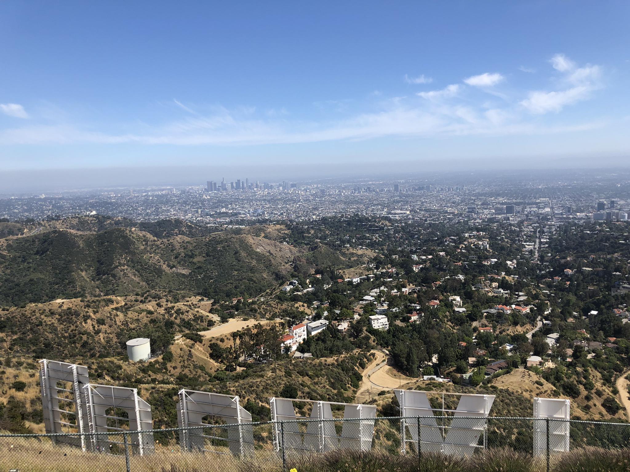 Large white letters on a dry hillside overlooking a sprawling city.