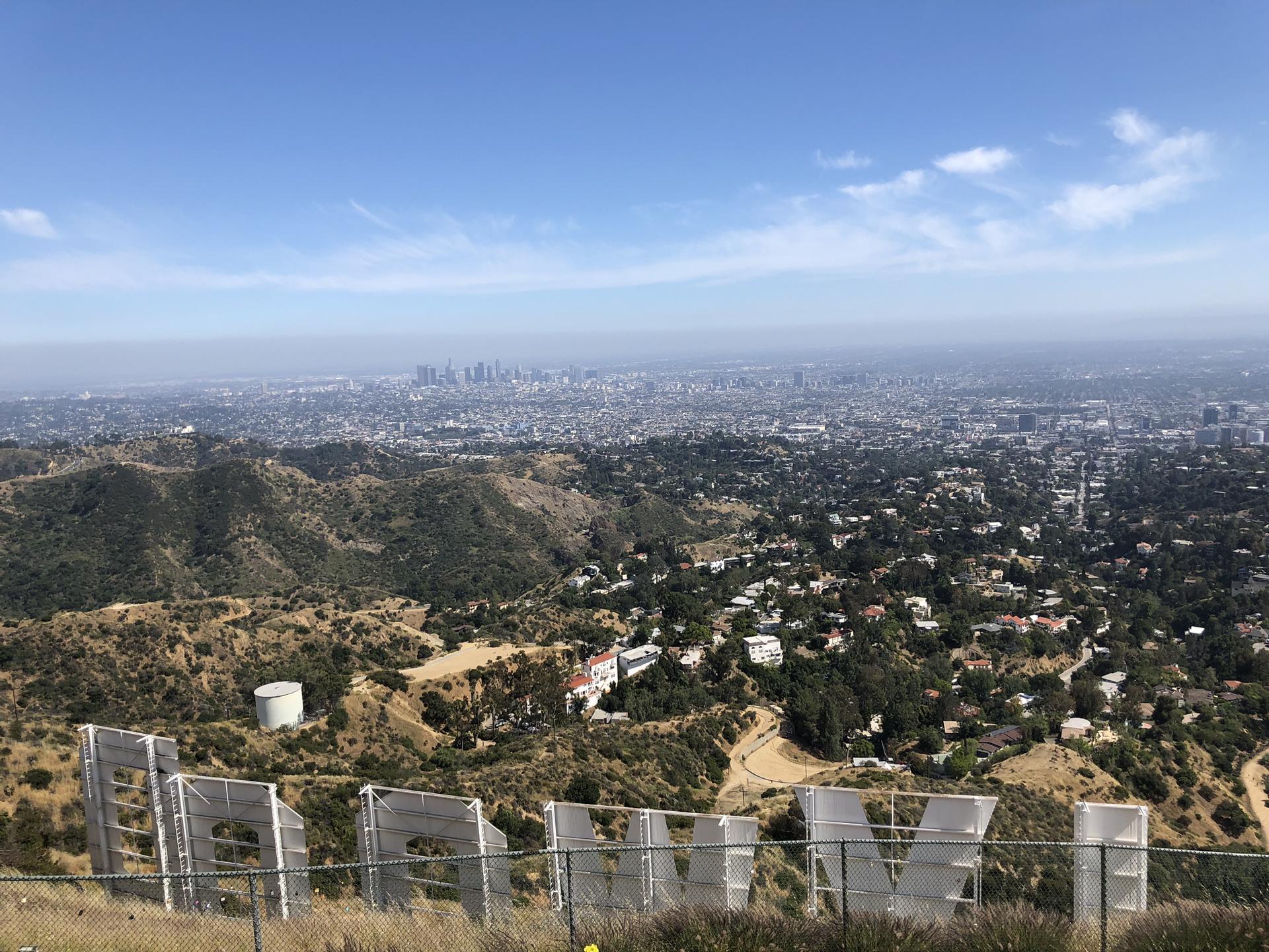 Large white letters on a dry hillside overlooking a sprawling city.