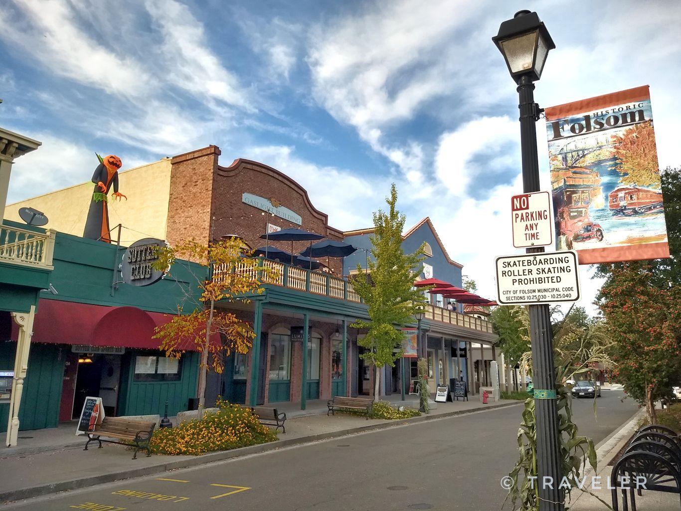 A street lined with colorful historic buildings and a lamppost under a cloudy sky.
