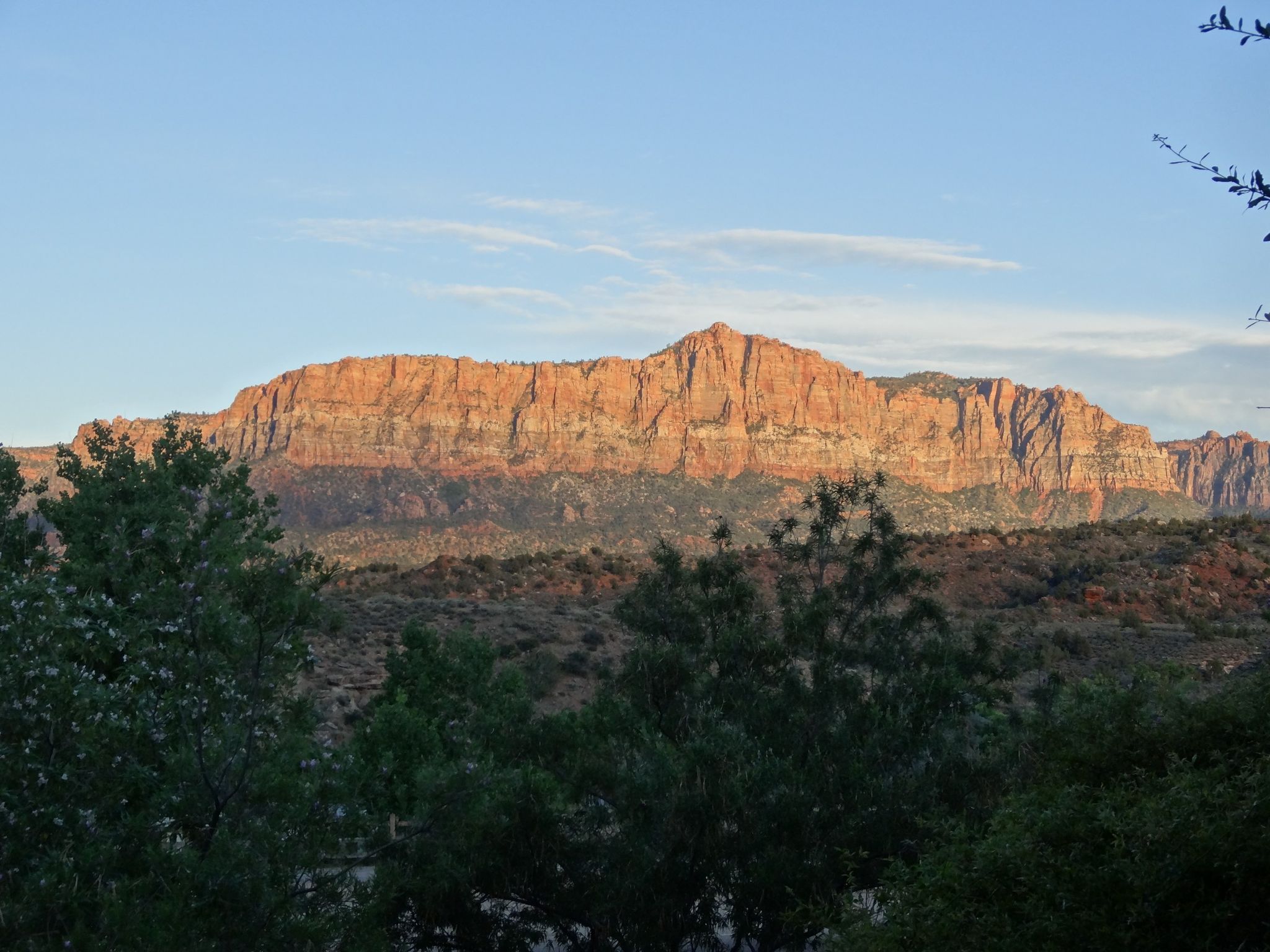 Wide view of a large, reddish mountain range under a clear sky. - View to South Mountain – Majestic View Lodge loop from Springdale