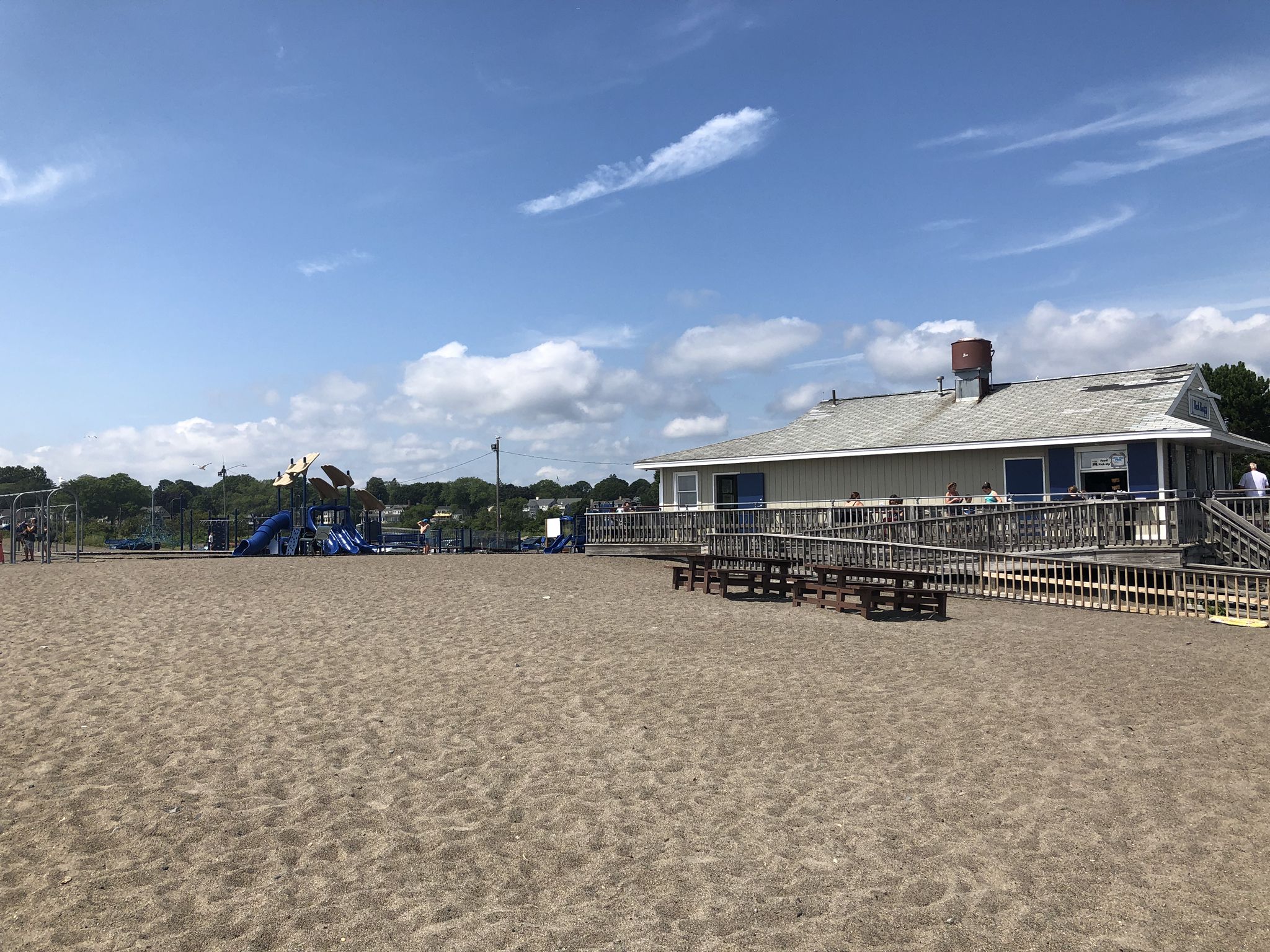 Sandy beach with playground, building, and people under a sunny sky. - Marblehead & Winter Island loop from Beverly