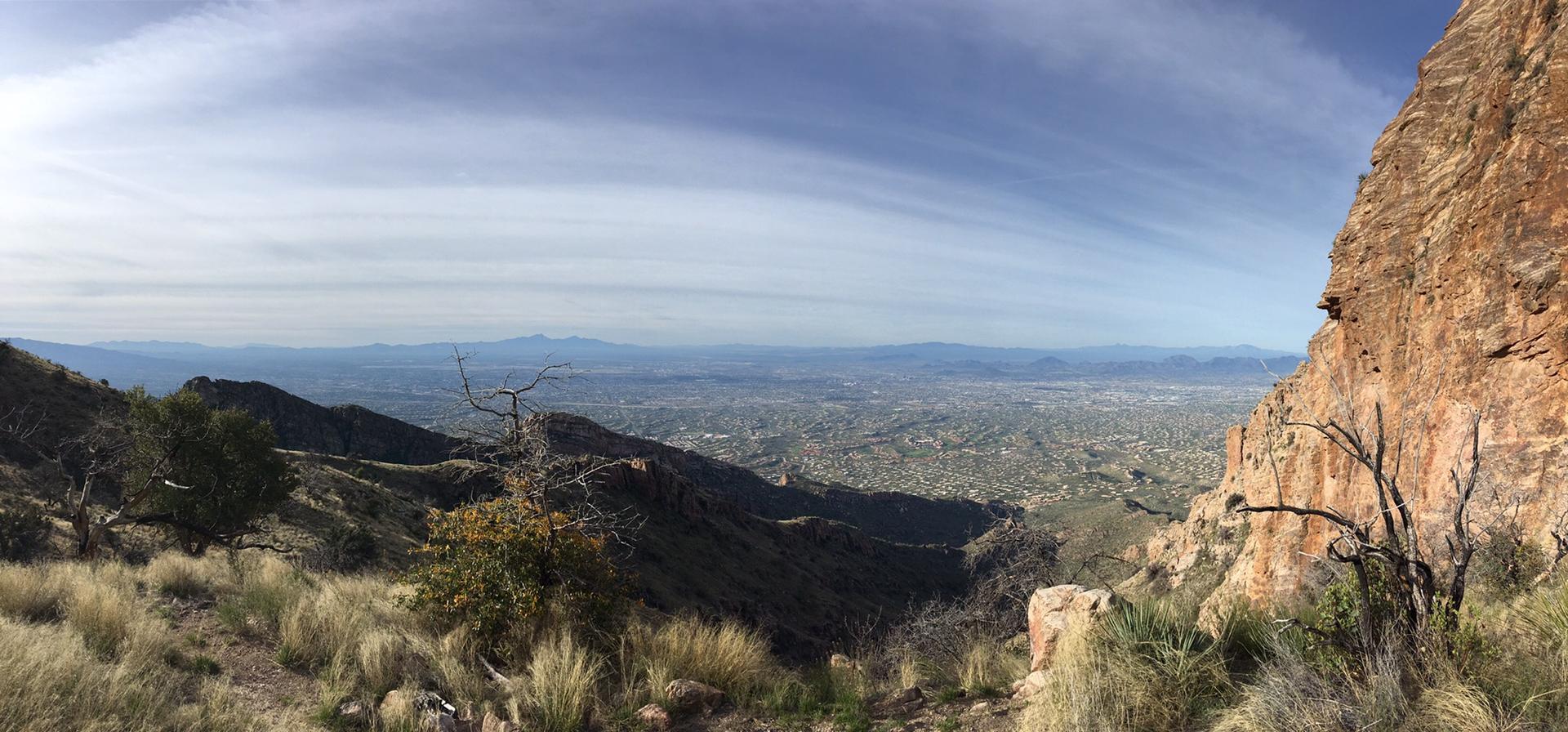 Wide panoramic view of a city in a valley from a rocky mountain.