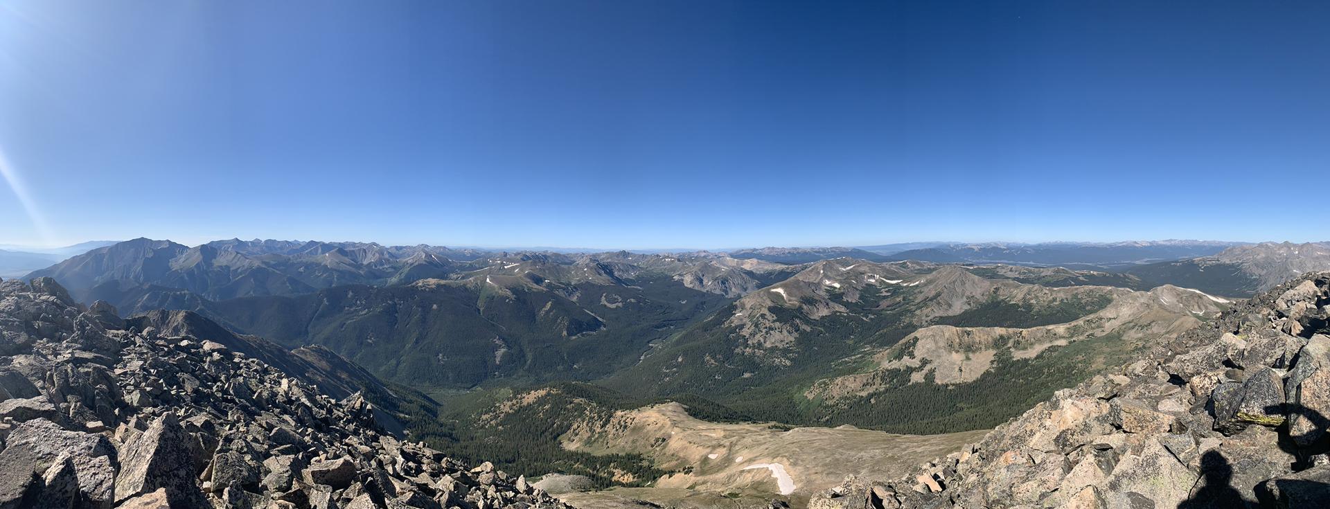 Panoramic view of vast mountain ranges under a clear blue sky.
