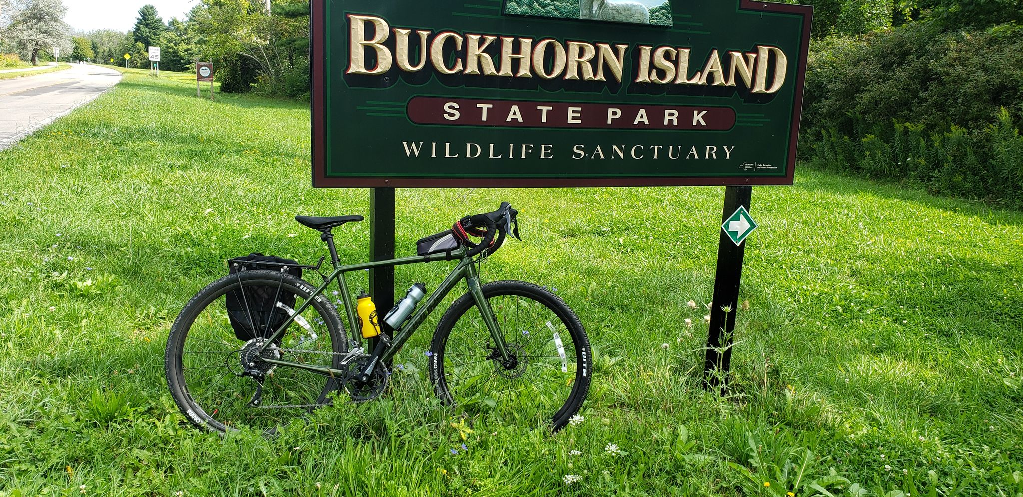 A bicycle with gear parked beside a park sign on a bright day. - West River Trail – East River Trail loop from Lamoka Island