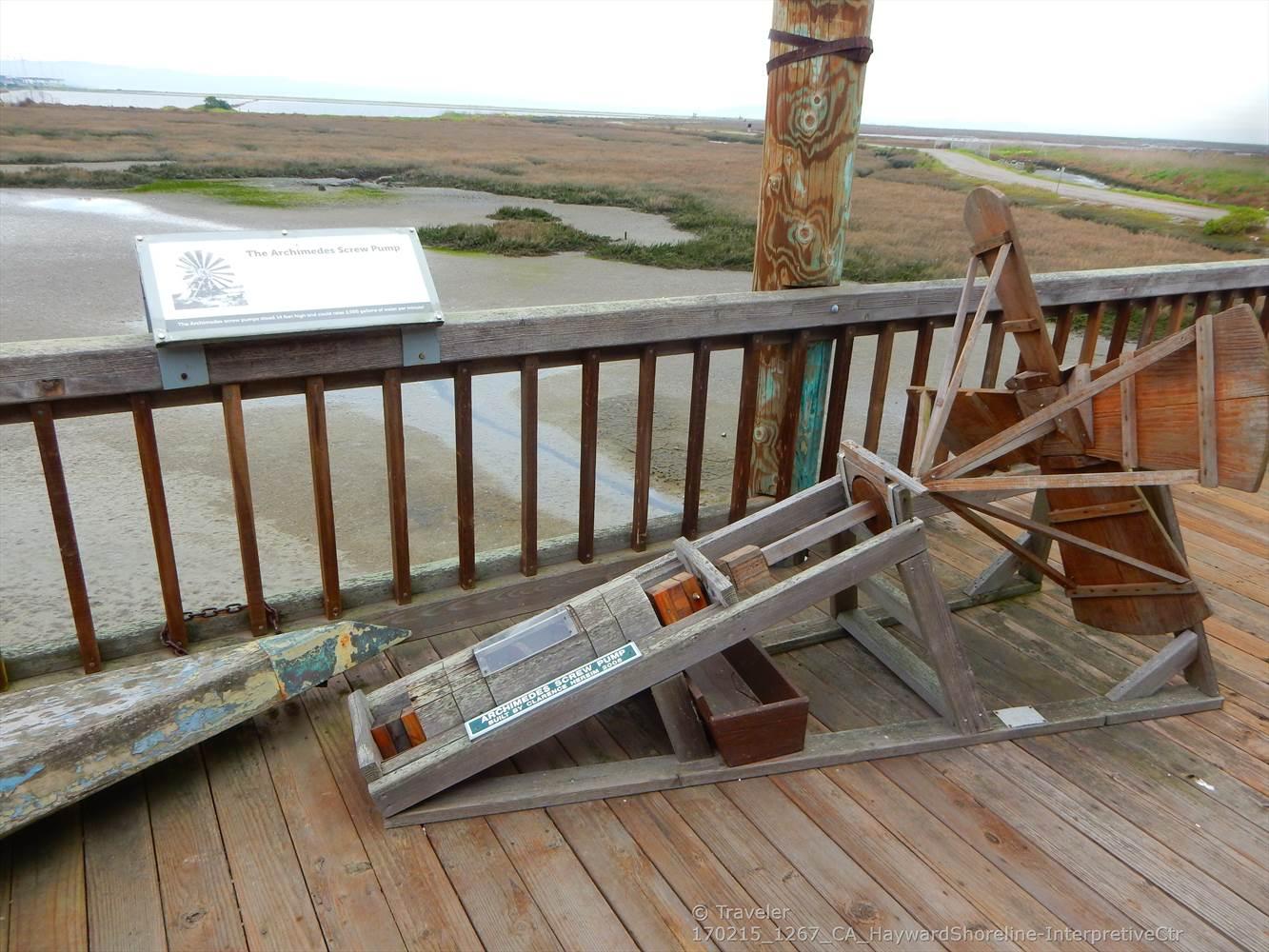 Wooden deck with interpretive display overlooking a vast marshland.
