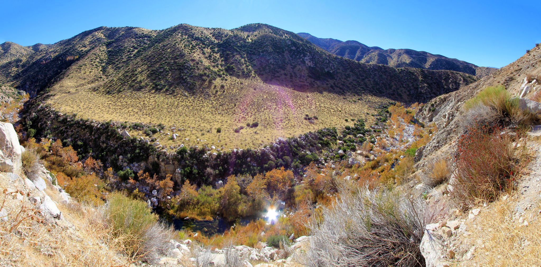 Panoramic view of a green valley winding through arid mountains. - Rainbow Bridge via Pacific Crest Trail