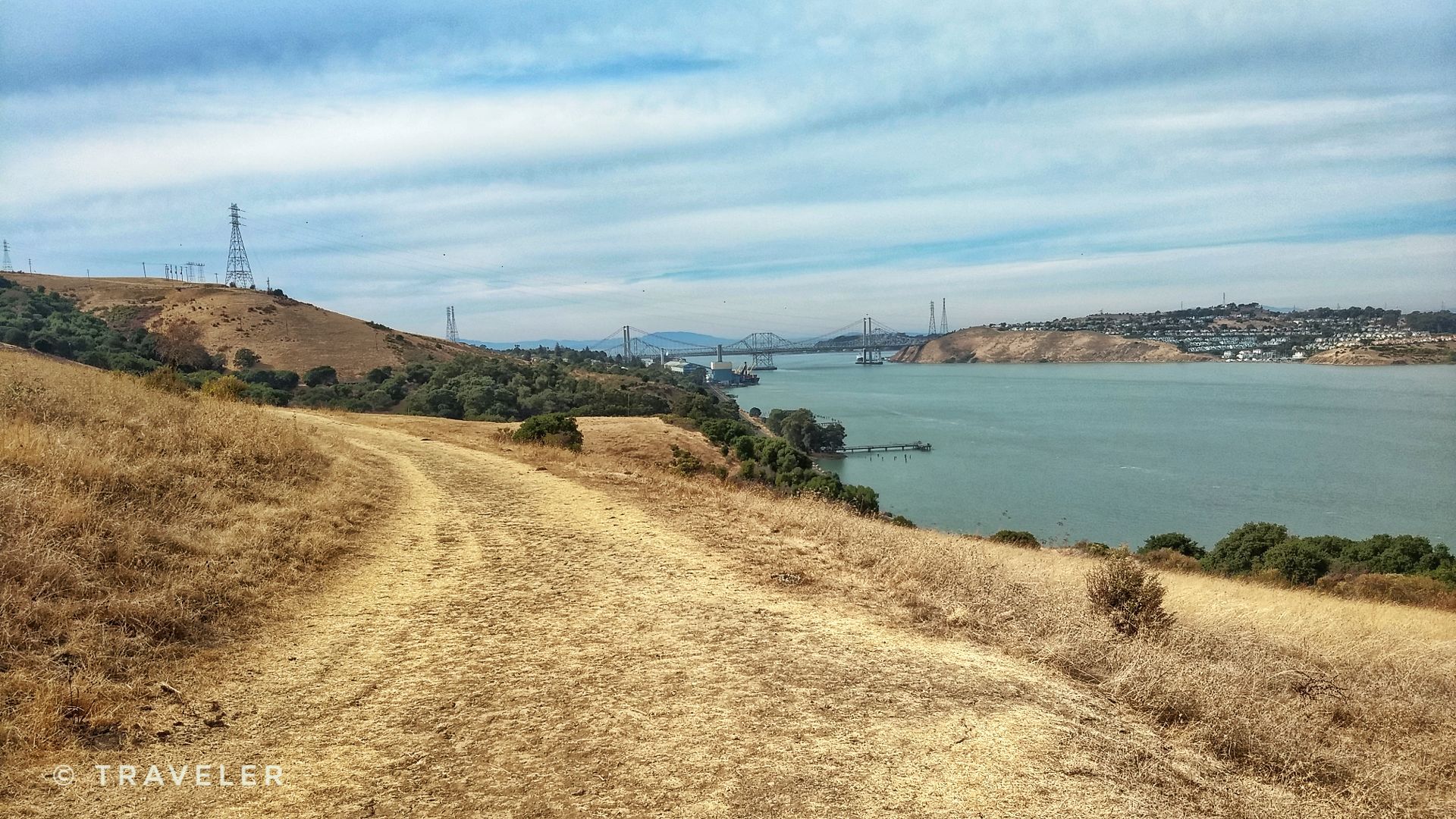 Dirt path winding through dry hills overlooking a large body of water. - Bull Valley and Carquinez Loop Overlook Trail
