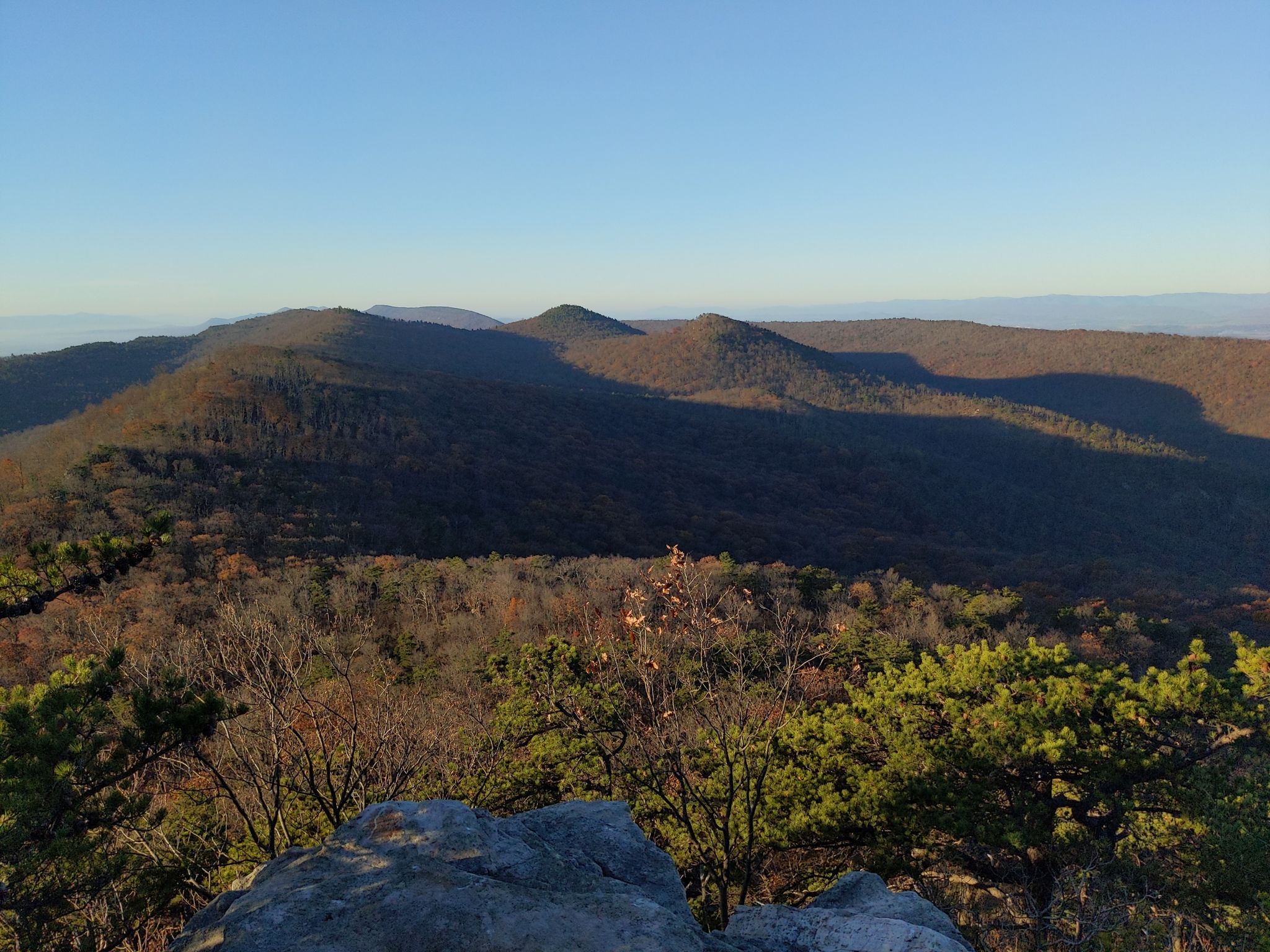 Sunny view of forested mountain ridges with long shadows under a clear blue sky. - Hiking loop from Peach Orchard Gap Parking