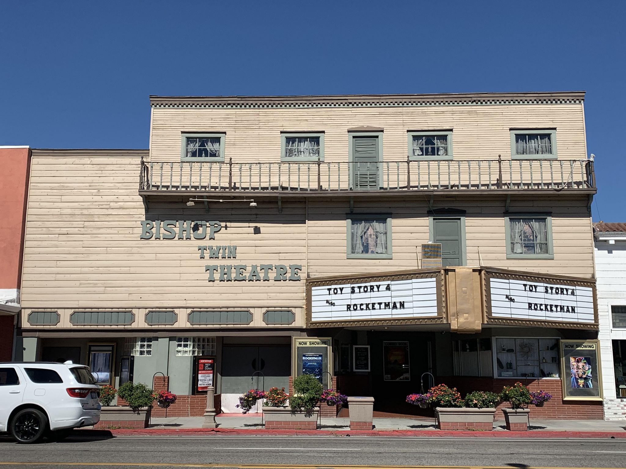 Old theater building with a marquee showing "Toy Story" and a parked car. - Benton Hot Springs to Bishop, California via Grand Army of the Republic Highway