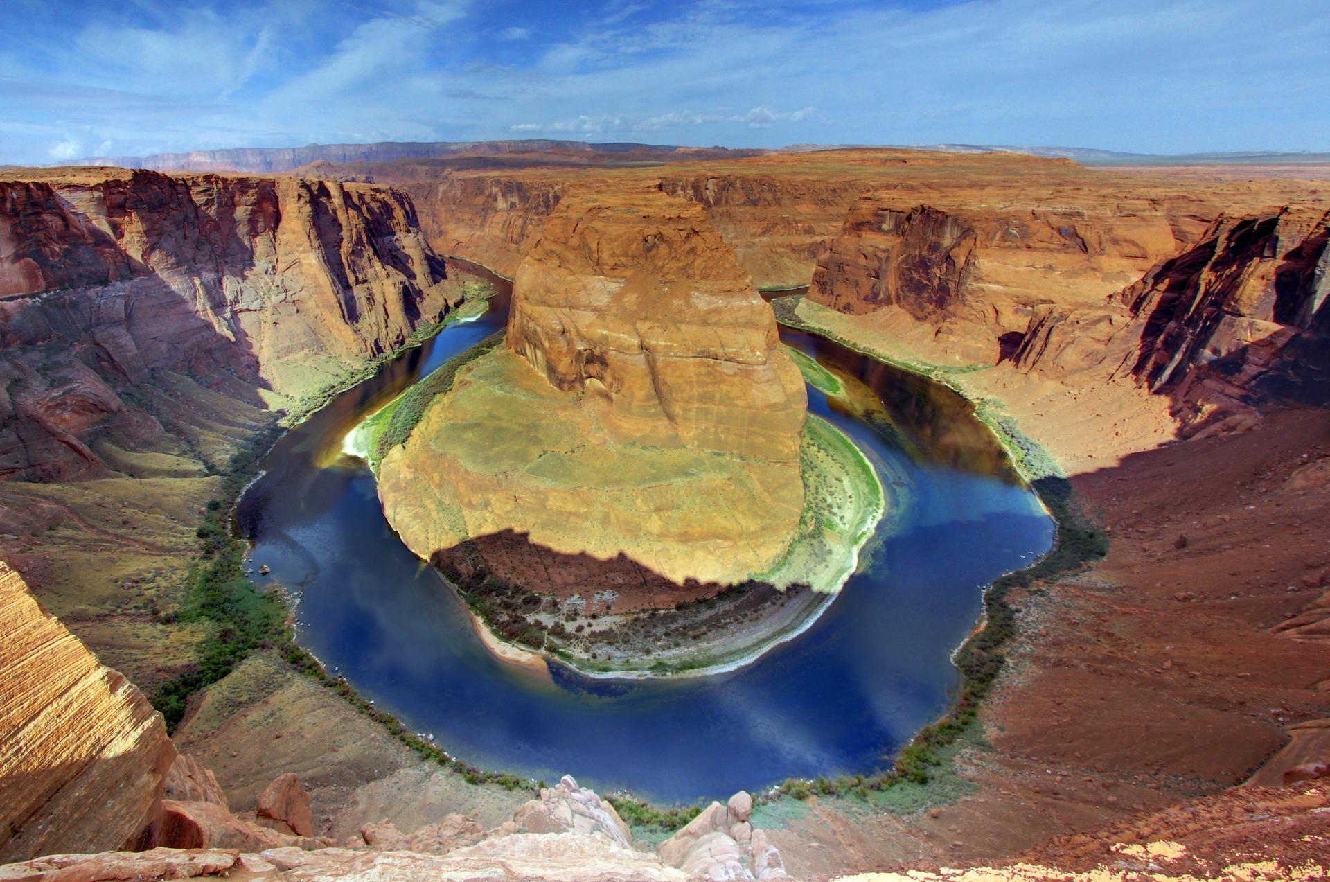 Wide aerial view of a horseshoe-shaped river bend in a vast canyon.