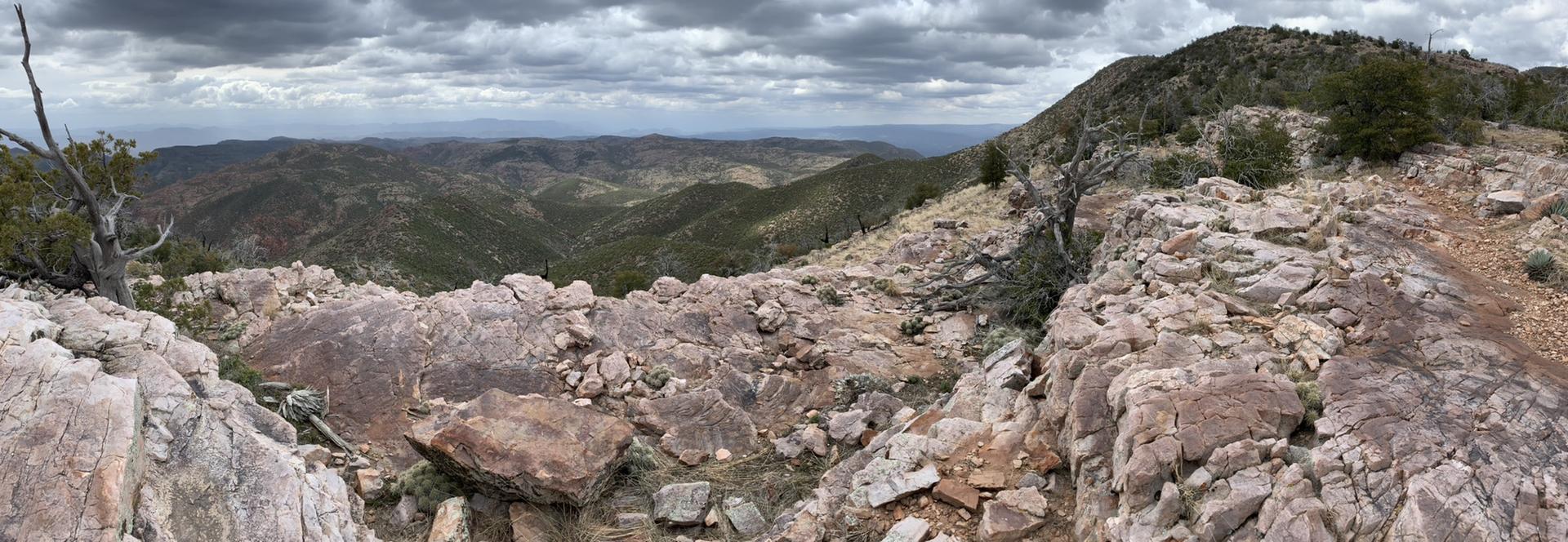 Panoramic view of rugged, rocky mountains under a cloudy sky.