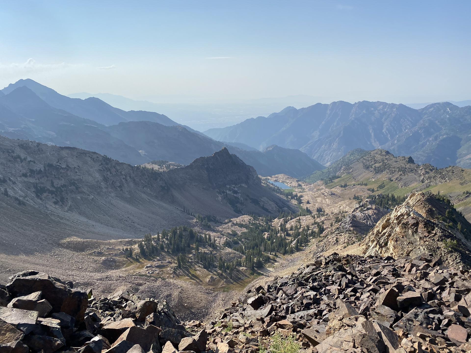 Rocky mountain vista overlooking a valley with a small lake.