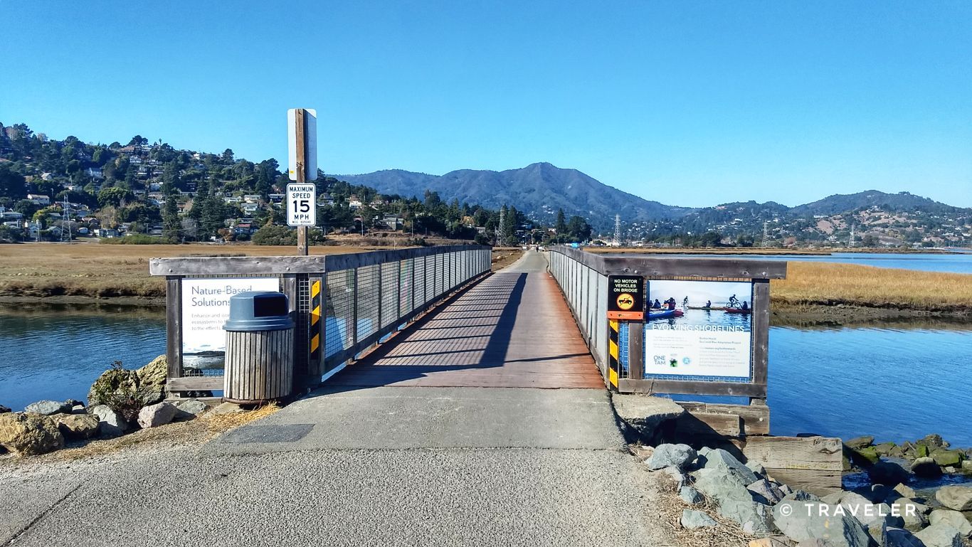 A sunny day view of a pedestrian bridge over marshland with distant hills. - Marincello Trail – Sausalito — Mill Valley Path loop from Alta