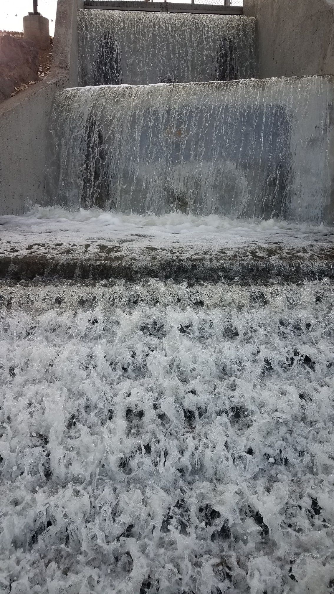 Close-up of a multi-tiered concrete waterfall with foamy water. - Prescott Valley Bicycle Route 1 Loop
