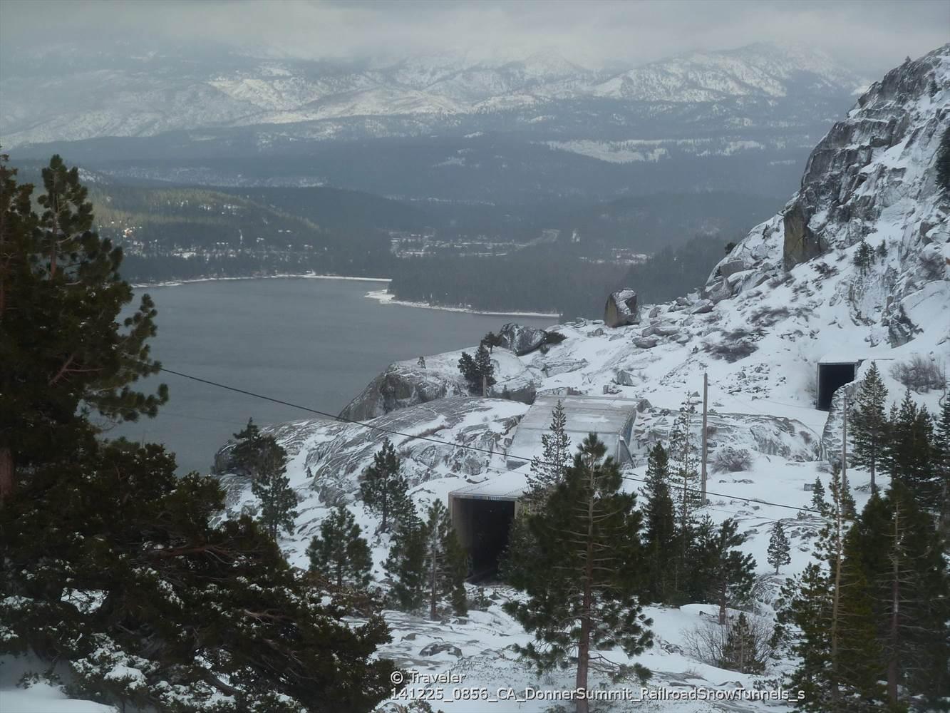 Snowy mountain landscape with a lake, pine trees, and dark tunnel entrances.
