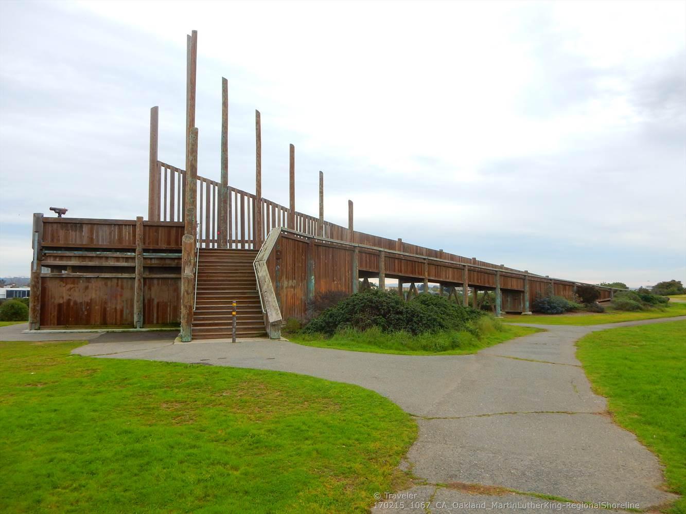 Large wooden elevated walkway with stairs on a cloudy day.