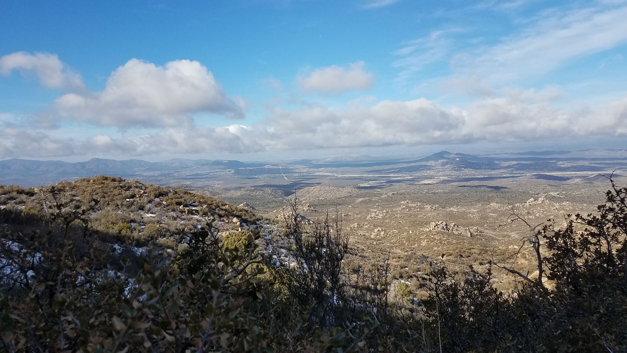 Panoramic view of a vast, dry landscape with distant mountains under a cloudy sky. - Williams Peak Trail – Skull Valley Overlook loop from White Rock TraIlhead