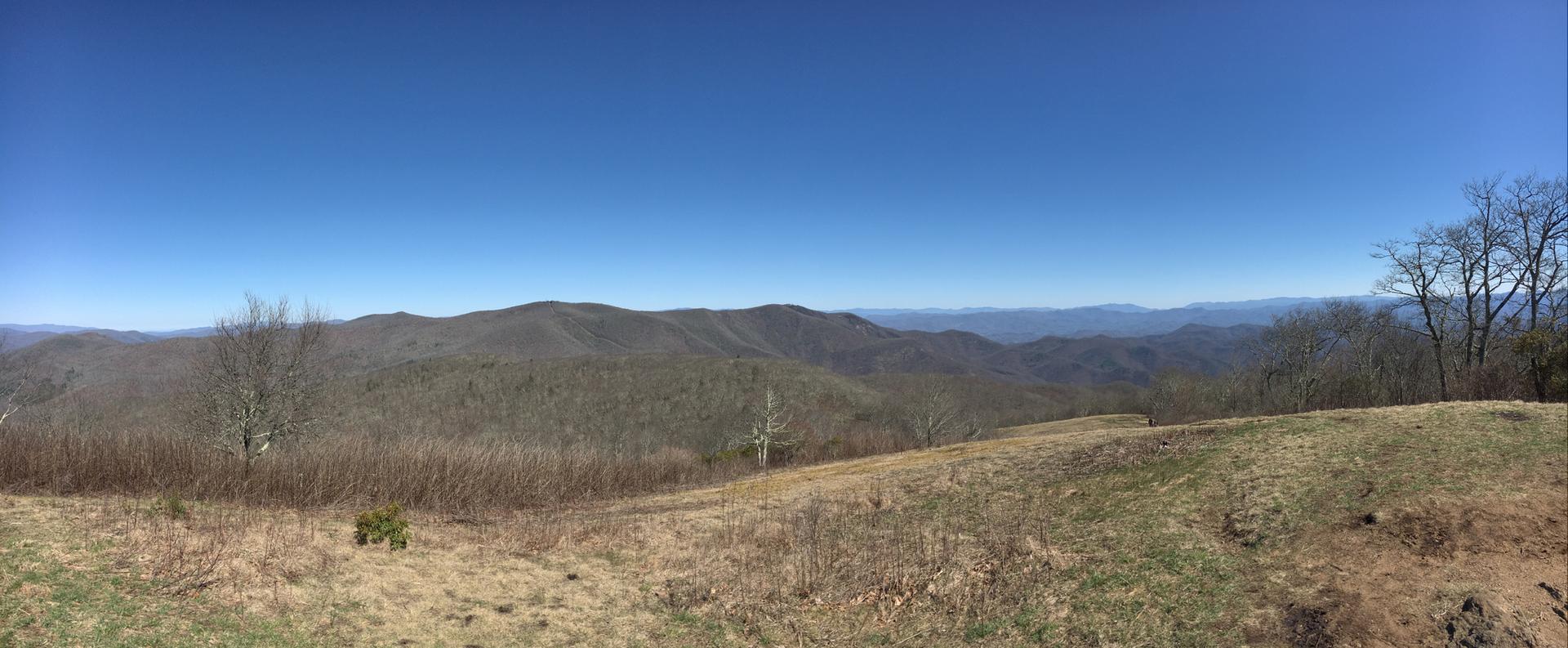 Panoramic view of distant, hazy mountains under a clear blue sky.