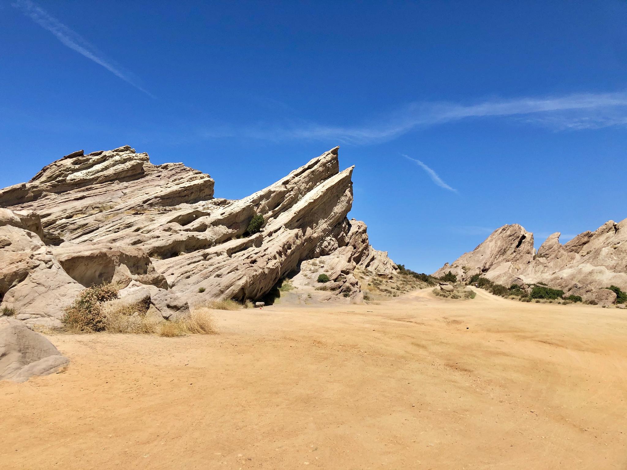Striking jagged rock formations in a desert landscape under a clear blue sky.