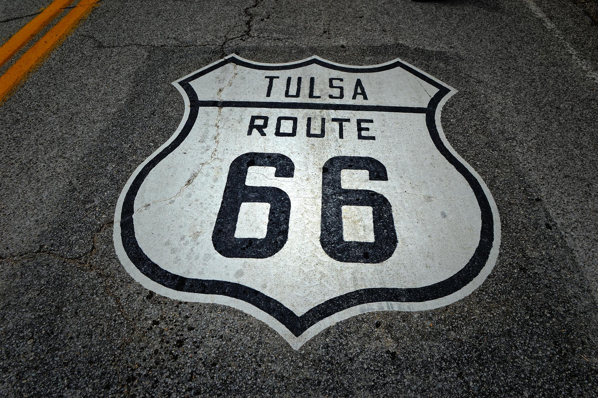 A large road shield symbol painted on dark asphalt with yellow lines.