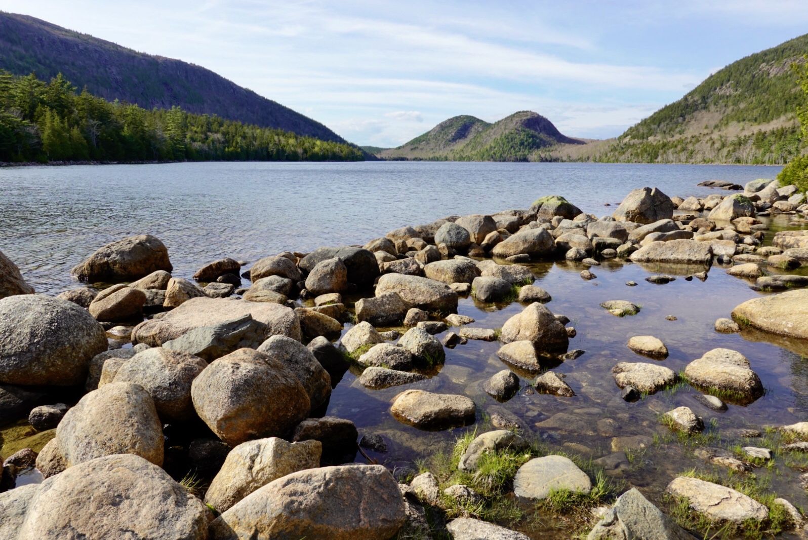 Rocky shore of a lake with mountains under a bright sky. - Jordan Pond Path and South Bubble Trail