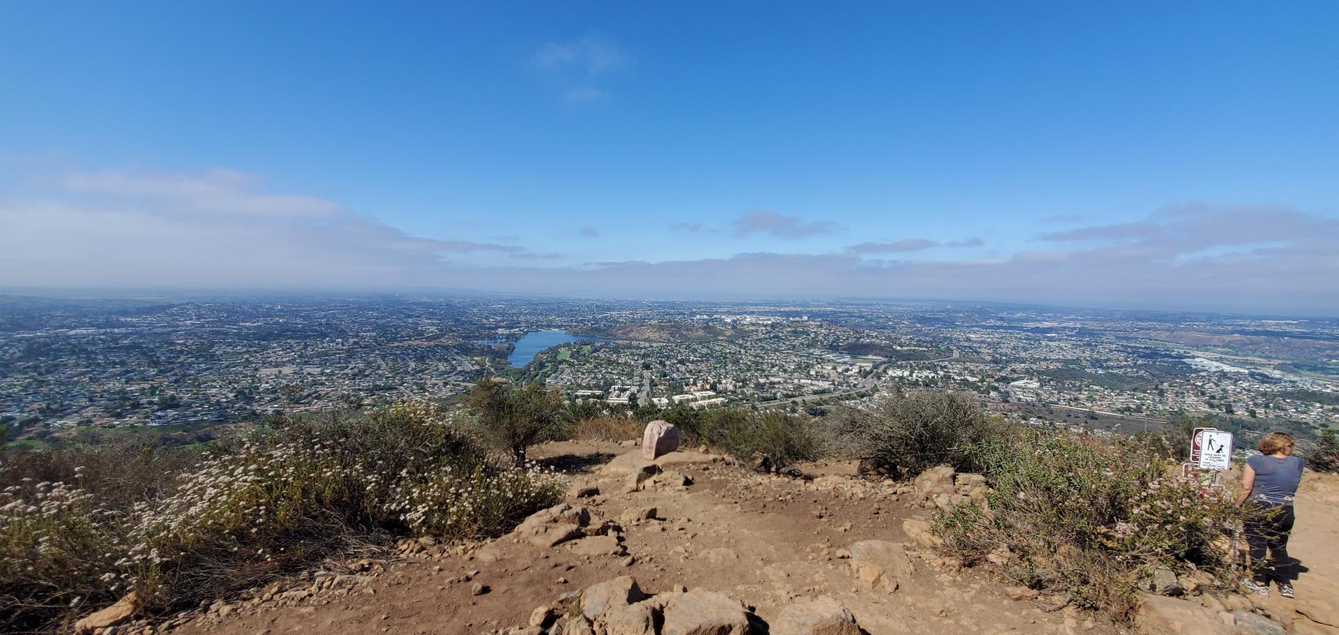 Panoramic city view from a rocky mountain peak on a clear day.