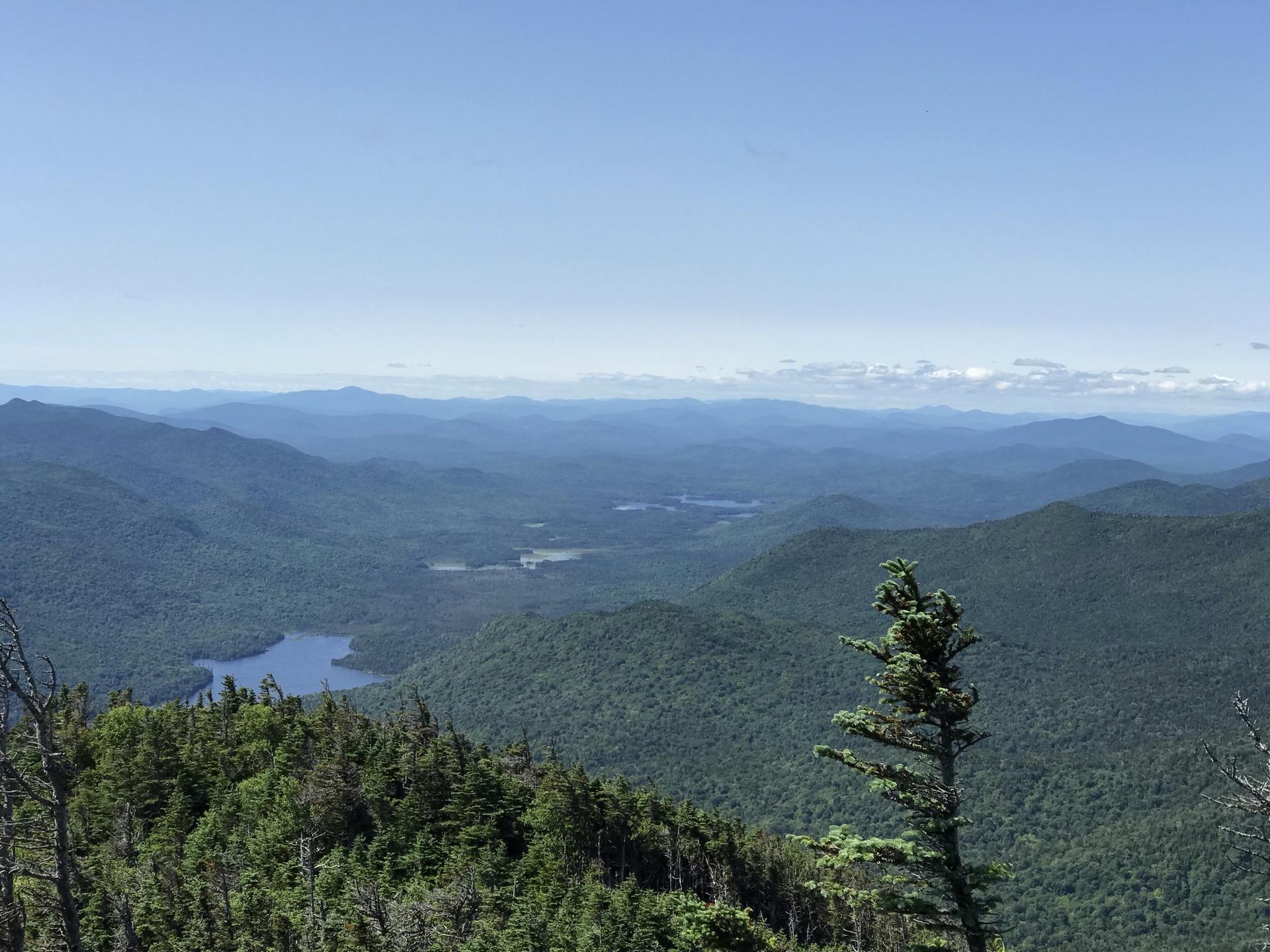 Vast mountain landscape with distant lakes under a clear blue sky.