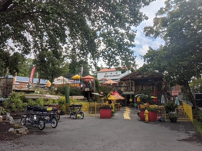 Lively outdoor restaurant area with colorful umbrellas and pedal carts. - Buddy Lou's Restaurant – Indigo Neck Primitive Campsite loop from Fort Frederick State Park